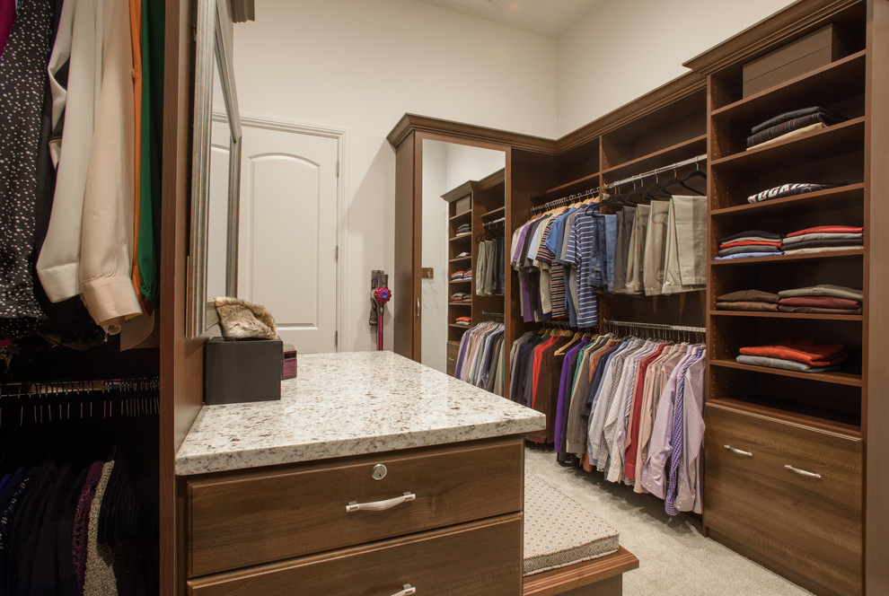 Example of a large walk-in closet design in Denver with medium tone wood cabinets