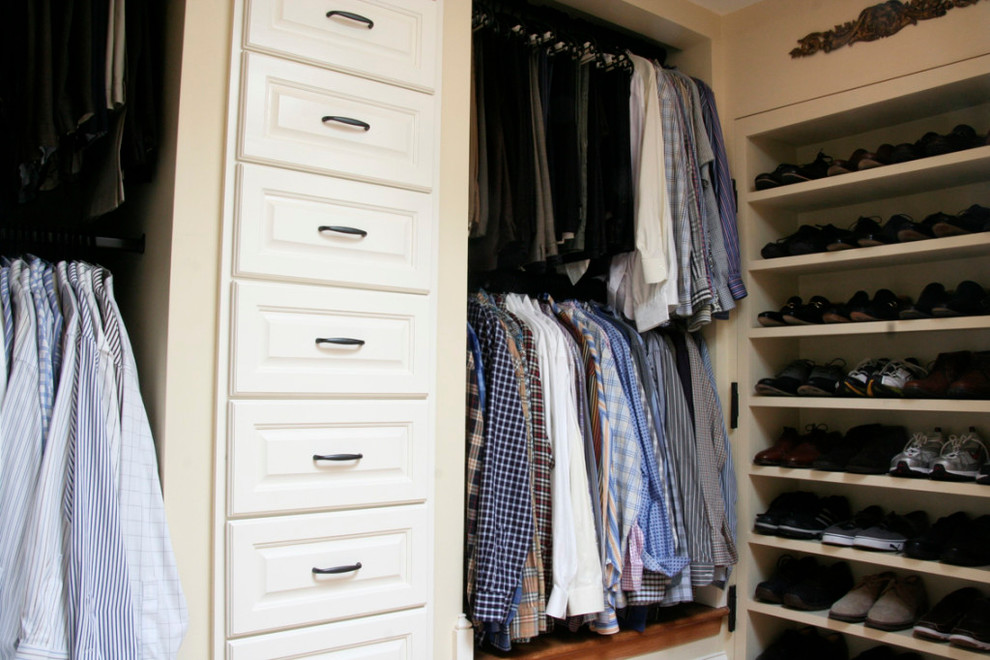 Diseño de armario vestidor unisex tradicional de tamaño medio con armarios con paneles con relieve, puertas de armario blancas y suelo de madera en tonos medios