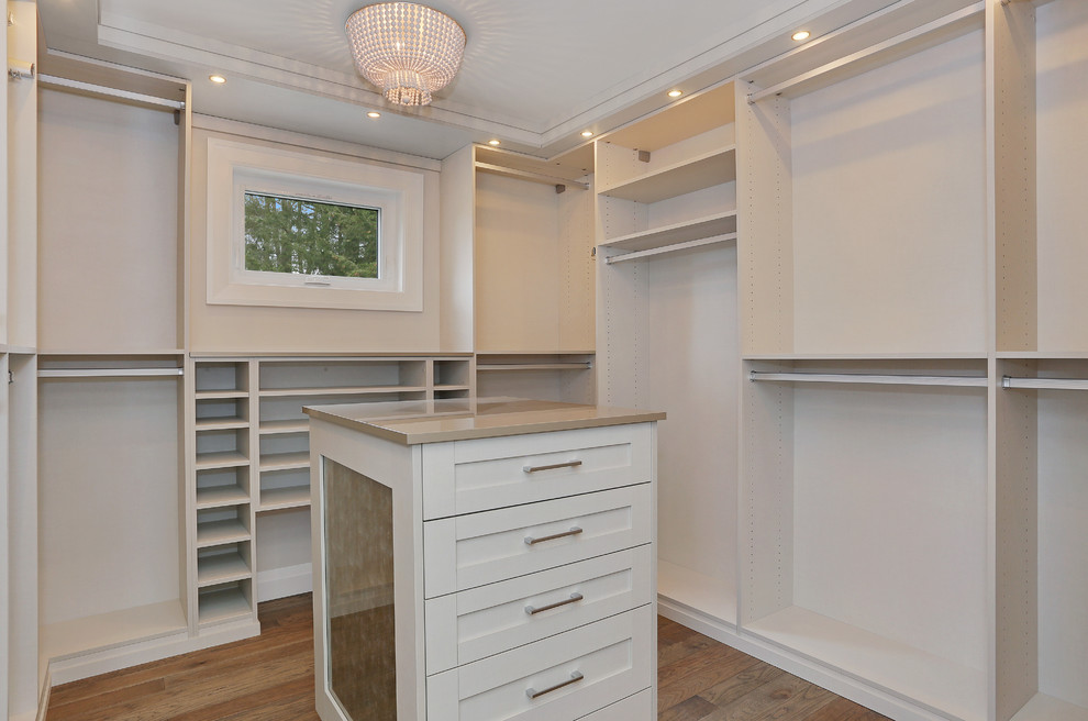 Ejemplo de armario vestidor unisex de estilo americano de tamaño medio con armarios estilo shaker, puertas de armario blancas, suelo de madera clara y suelo beige