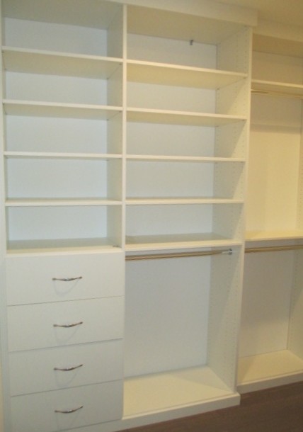 This is an example of a medium sized contemporary gender neutral walk-in wardrobe in Los Angeles with flat-panel cabinets, white cabinets, medium hardwood flooring and brown floors.