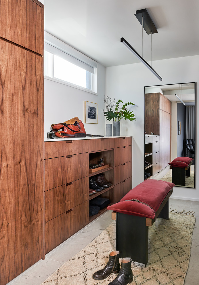 Inspiration pour un dressing room minimaliste en bois brun neutre avec un placard à porte plane et un sol beige.