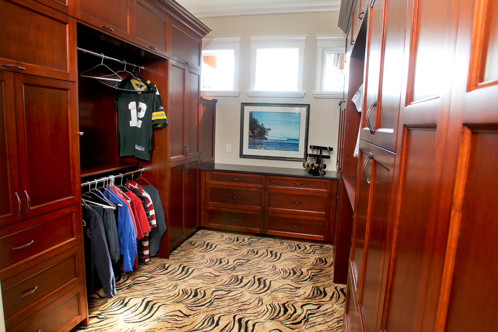 Ejemplo de armario vestidor unisex tradicional grande con armarios con paneles empotrados, puertas de armario de madera en tonos medios y moqueta