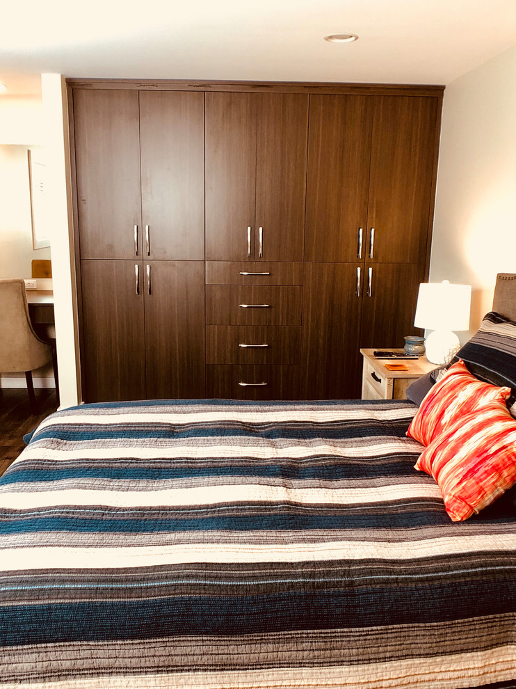 Ejemplo de dormitorio minimalista de tamaño medio con suelo de madera en tonos medios y suelo marrón