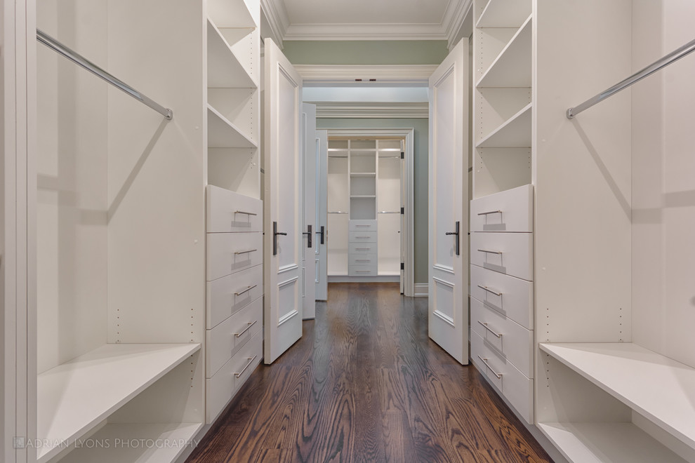 Example of a huge classic gender-neutral medium tone wood floor walk-in closet design in Toronto with open cabinets and white cabinets
