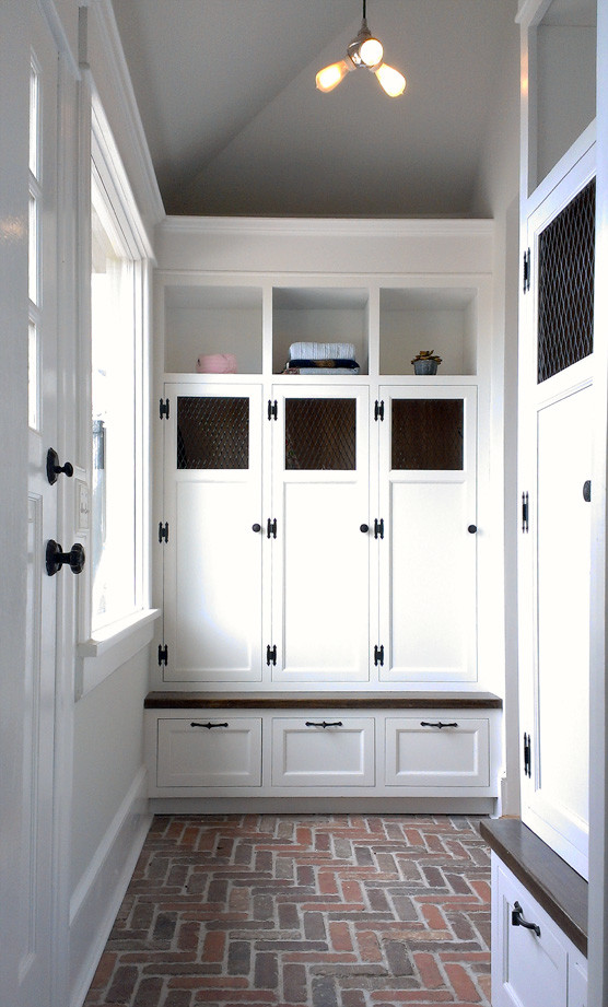 Inspiration för små klassiska walk-in-closets för könsneutrala, med luckor med infälld panel, vita skåp, tegelgolv och rött golv