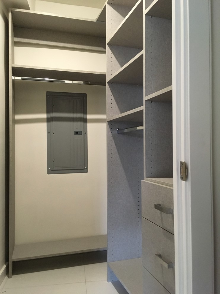Cette photo montre un petite dressing et rangement moderne neutre avec un placard à porte plane, des portes de placard grises, un sol en carrelage de céramique et un sol gris.