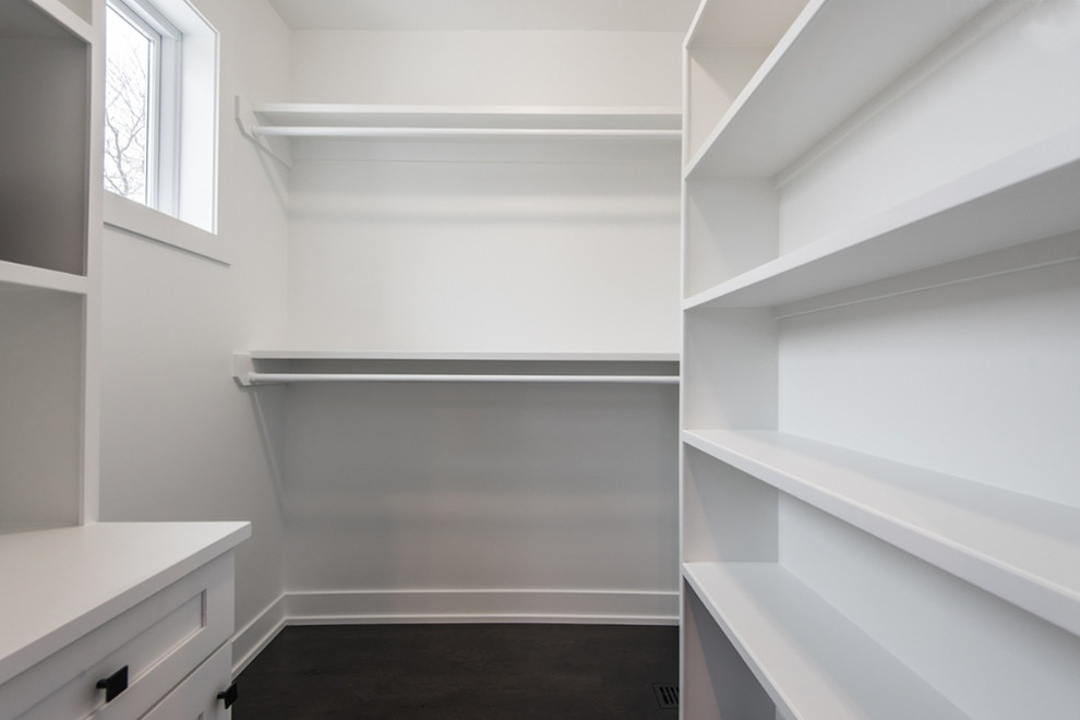 Design ideas for a medium sized contemporary gender neutral walk-in wardrobe in Chicago with shaker cabinets, white cabinets and black floors.