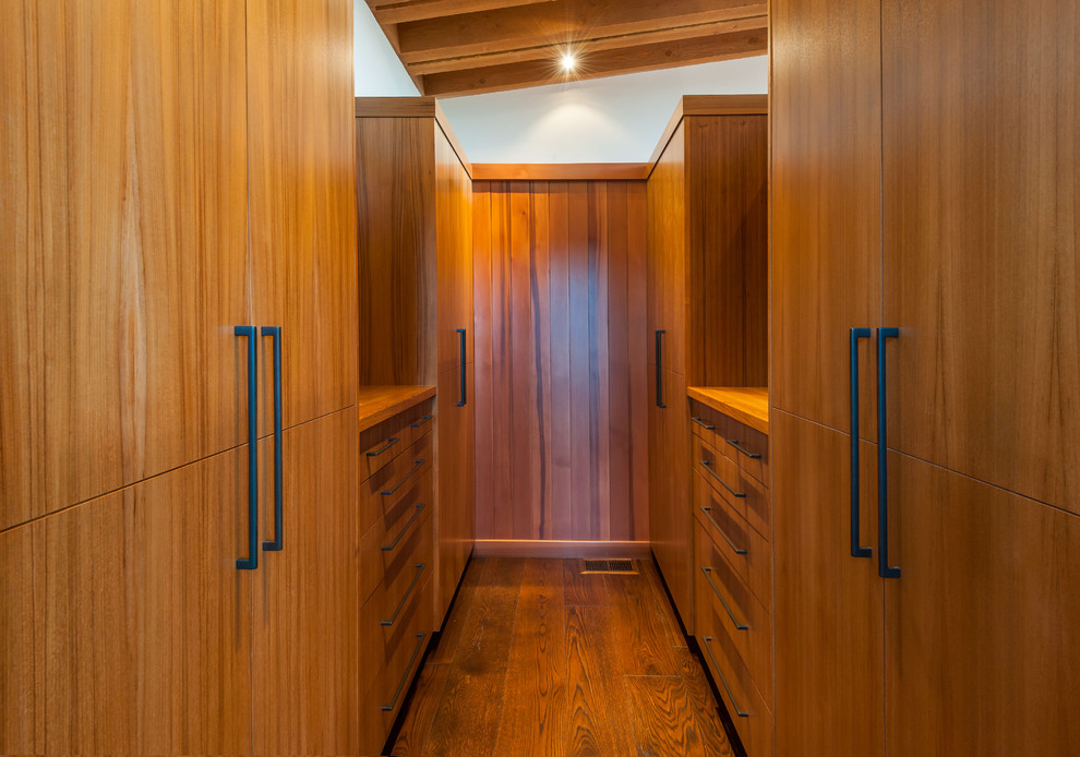 Idéer för ett modernt walk-in-closet, med släta luckor, skåp i mellenmörkt trä och mellanmörkt trägolv