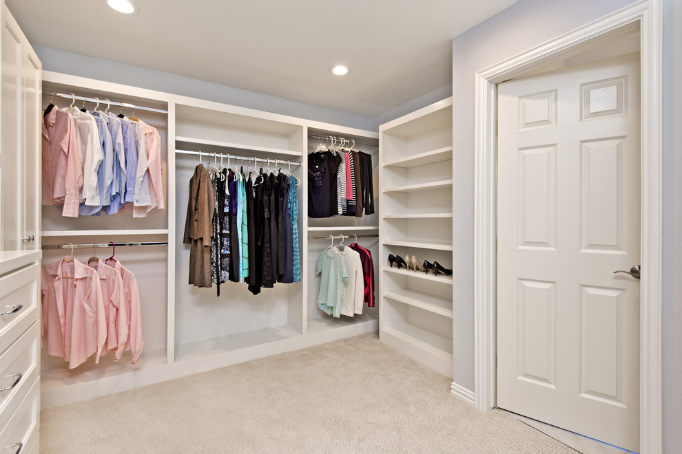 На фото: огромная гардеробная комната в классическом стиле с фасадами в стиле шейкер, белыми фасадами и ковровым покрытием для женщин