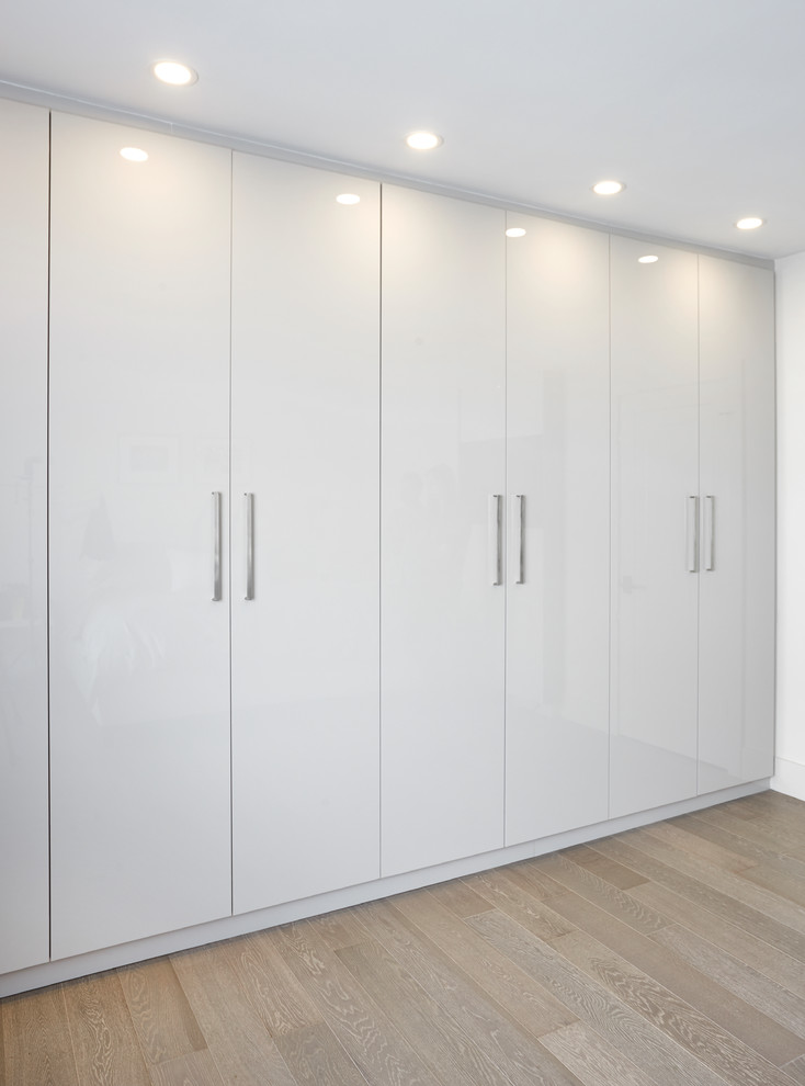 Idées déco pour une petite armoire encastrée moderne neutre avec un placard à porte plane et des portes de placard blanches.