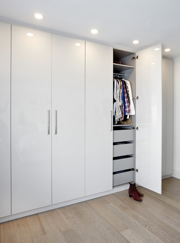 Ejemplo de armario y vestidor unisex minimalista pequeño con a medida, armarios con paneles lisos y puertas de armario blancas