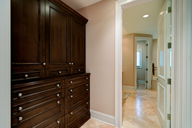Exemple d'un grand dressing room chic en bois foncé neutre avec un placard à porte plane et un sol en carrelage de céramique.