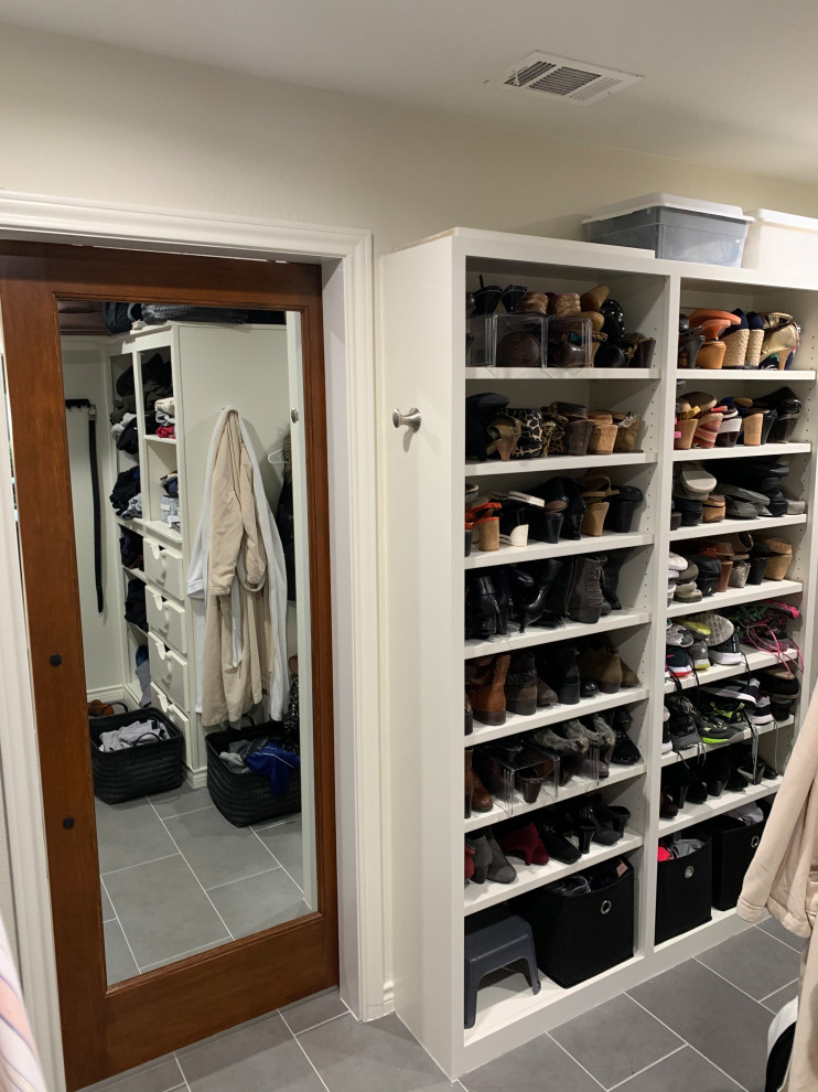 Imagen de armario vestidor unisex minimalista de tamaño medio con armarios abiertos, puertas de armario blancas, suelo de baldosas de porcelana y suelo gris