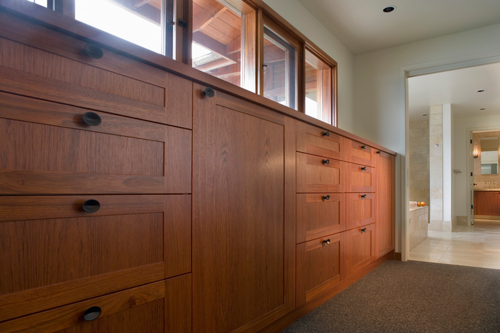 Example of a mid-sized trendy gender-neutral dressing room design in Other with flat-panel cabinets and medium tone wood cabinets