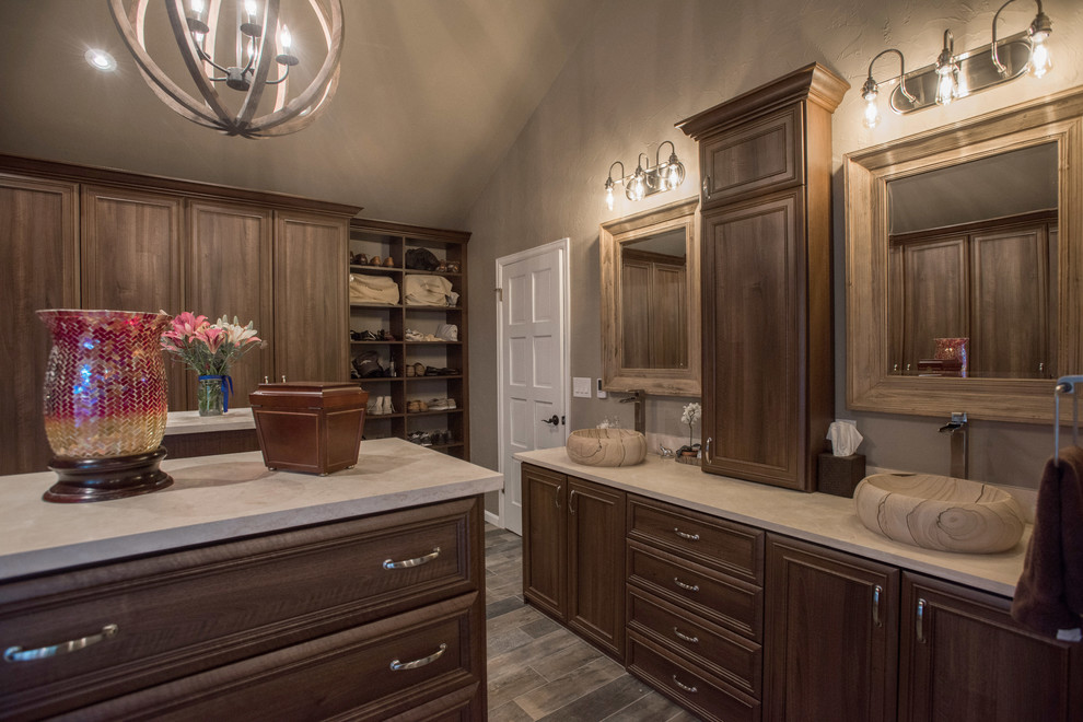 Inspiration for a large transitional limestone floor and gray floor walk-in closet remodel in Denver with recessed-panel cabinets and medium tone wood cabinets