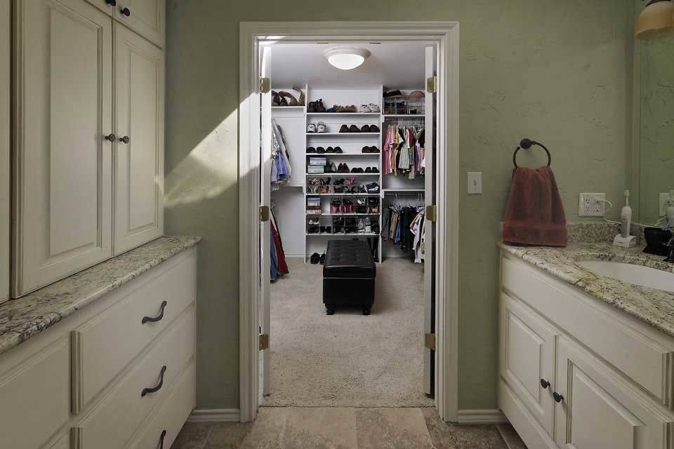 Imagen de vestidor unisex moderno de tamaño medio con armarios abiertos, puertas de armario blancas, moqueta y suelo gris