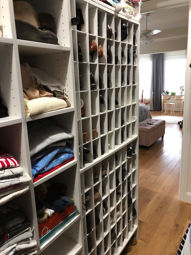 This is an example of a large traditional gender neutral walk-in wardrobe in DC Metro with open cabinets, grey cabinets, medium hardwood flooring and beige floors.