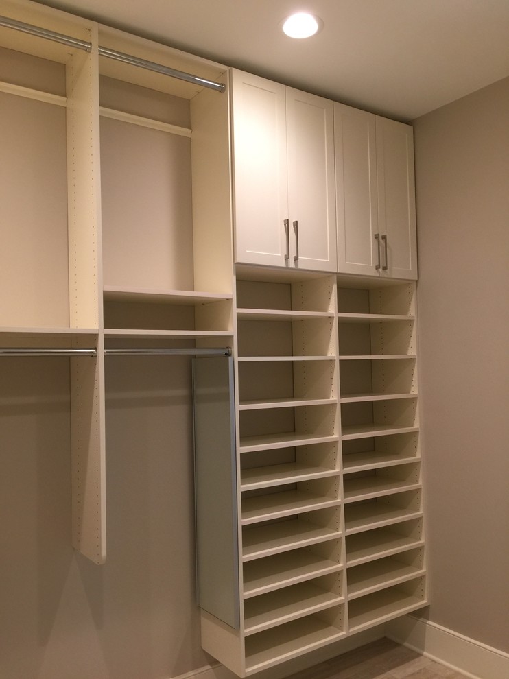 Inspiration for a mid-sized transitional gender-neutral light wood floor and beige floor walk-in closet remodel in Other with shaker cabinets and white cabinets