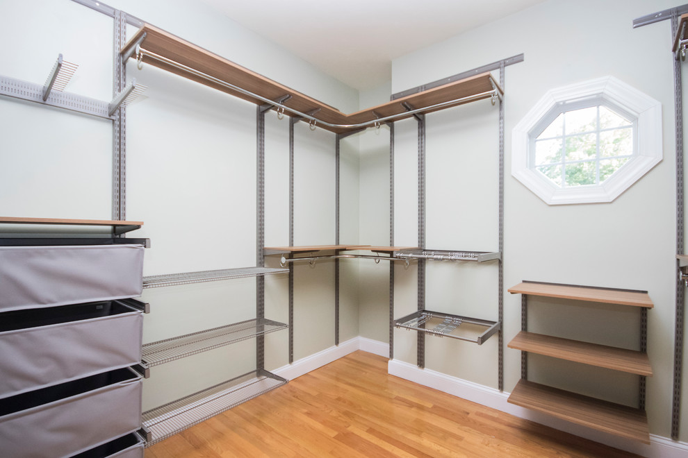 This is an example of an expansive modern gender neutral walk-in wardrobe in Providence with flat-panel cabinets, medium wood cabinets, medium hardwood flooring and brown floors.