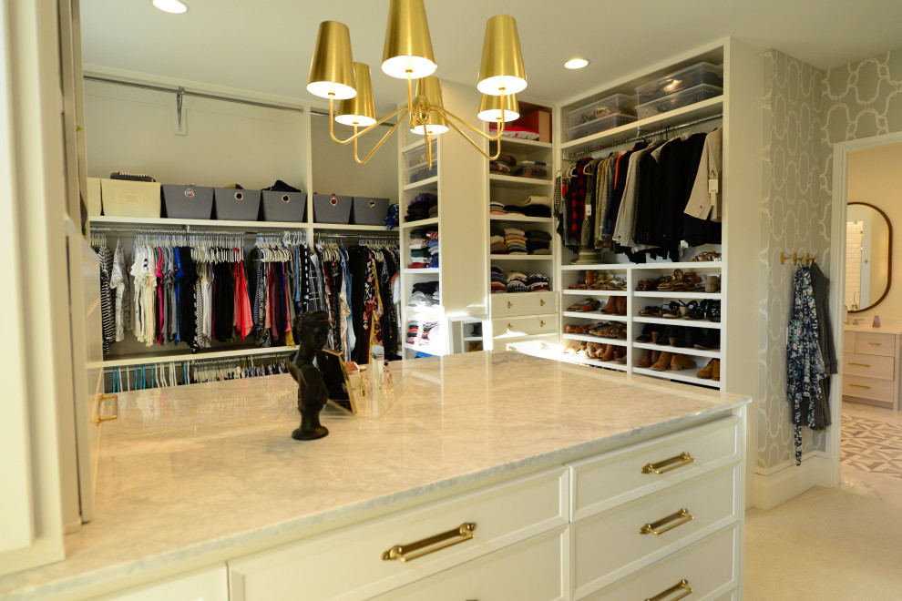 Modelo de armario vestidor unisex grande con armarios con paneles empotrados, puertas de armario beige, moqueta y suelo beige