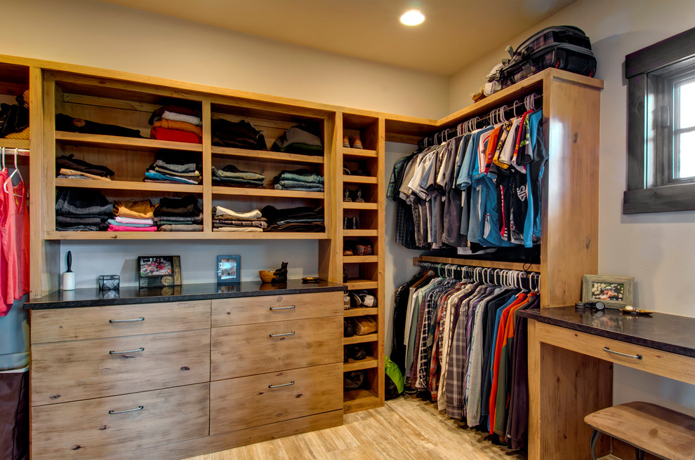Rustic wardrobe for men in Denver with flat-panel cabinets, light hardwood flooring and light wood cabinets.