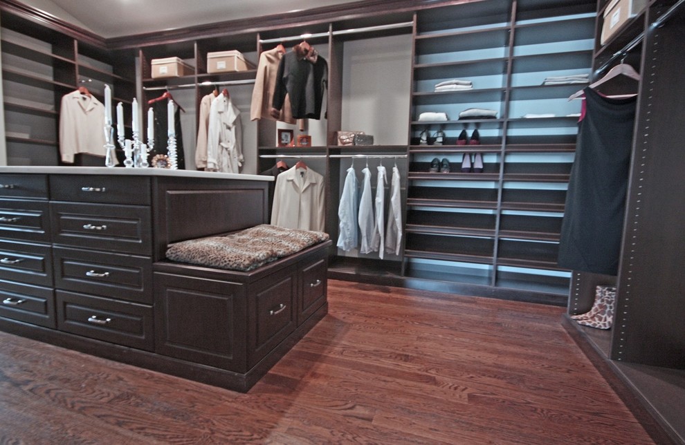 Idéer för ett mycket stort klassiskt walk-in-closet för könsneutrala, med luckor med upphöjd panel, bruna skåp, mellanmörkt trägolv och brunt golv