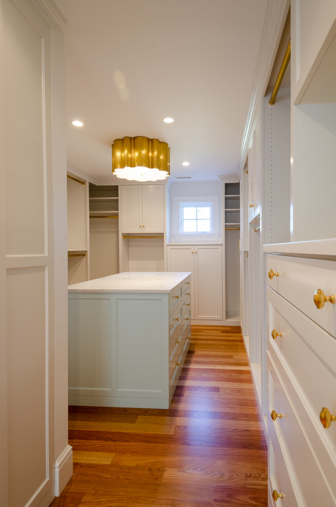 Inspiration for an expansive classic gender neutral walk-in wardrobe in Bridgeport with shaker cabinets, white cabinets, light hardwood flooring and beige floors.