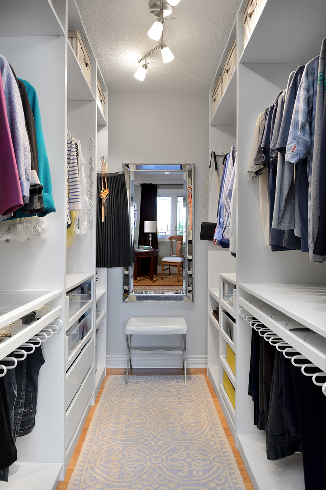 Example of a small transitional gender-neutral bamboo floor and beige floor walk-in closet design in Toronto with open cabinets and white cabinets