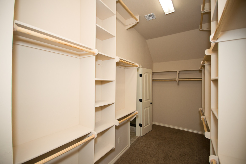 Aménagement d'un dressing classique de taille moyenne et neutre avec un placard sans porte, des portes de placard beiges et moquette.