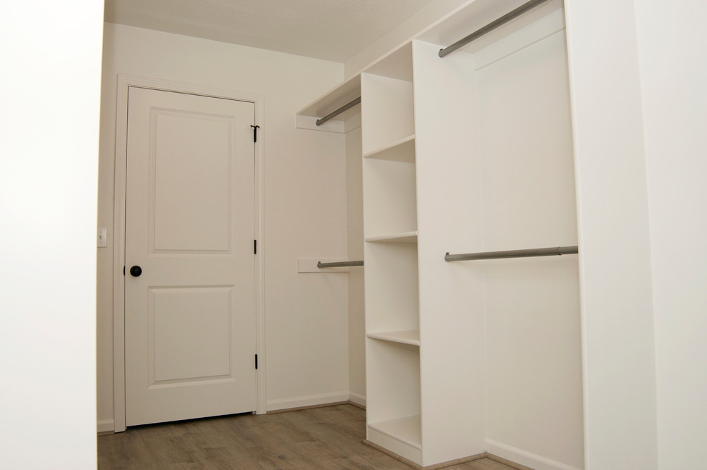 Ejemplo de armario vestidor unisex tradicional de tamaño medio con armarios abiertos, puertas de armario blancas, suelo de madera clara y suelo beige