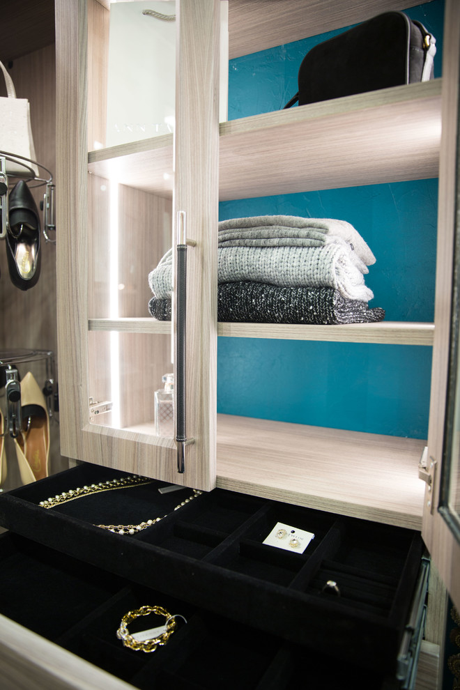Ejemplo de armario vestidor unisex contemporáneo pequeño con armarios tipo vitrina y puertas de armario de madera clara
