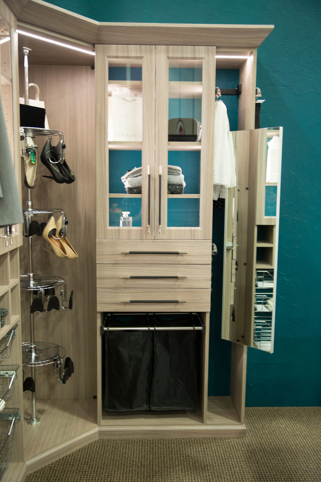Exempel på ett litet modernt walk-in-closet för könsneutrala, med luckor med glaspanel och skåp i ljust trä