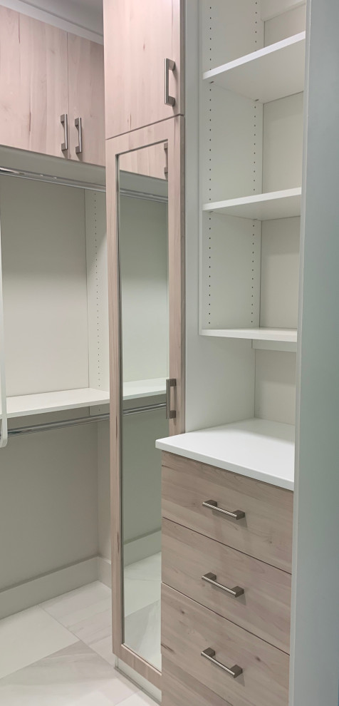 Immagine di una cabina armadio unisex minimalista di medie dimensioni con ante in legno chiaro