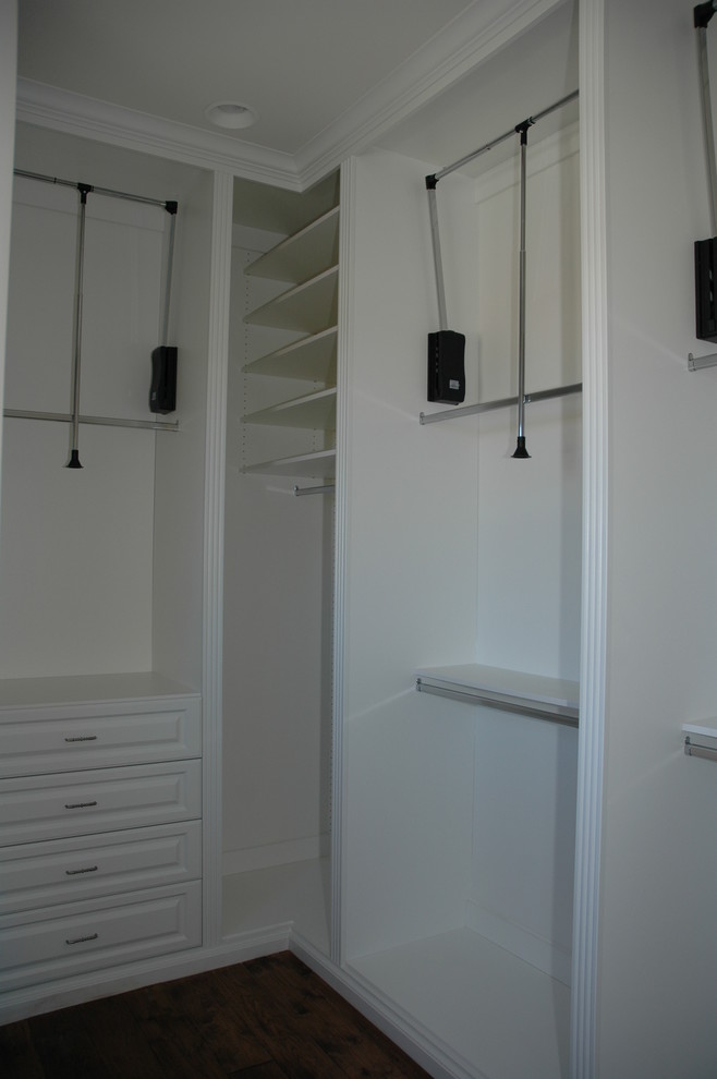 Immagine di una cabina armadio unisex chic con ante bianche e moquette