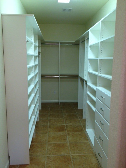 Imagen de vestidor unisex minimalista de tamaño medio con armarios con paneles lisos, puertas de armario blancas y suelo de baldosas de cerámica