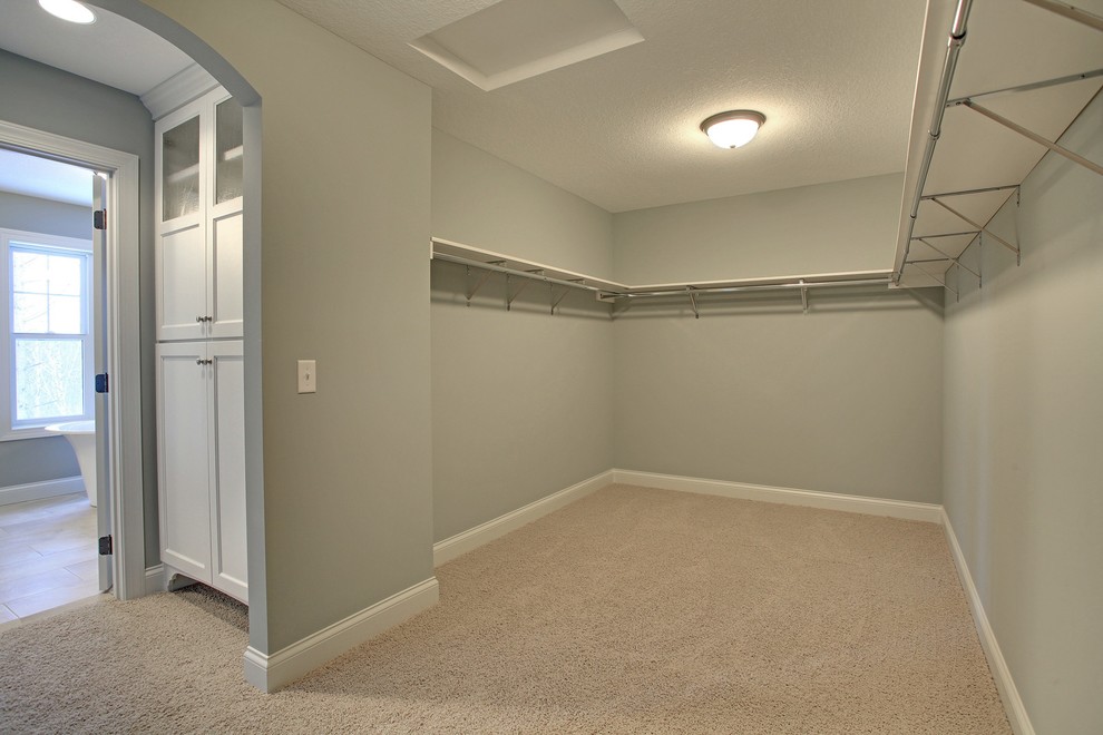 Свежая идея для дизайна: большая гардеробная комната унисекс в стиле неоклассика (современная классика) с ковровым покрытием - отличное фото интерьера