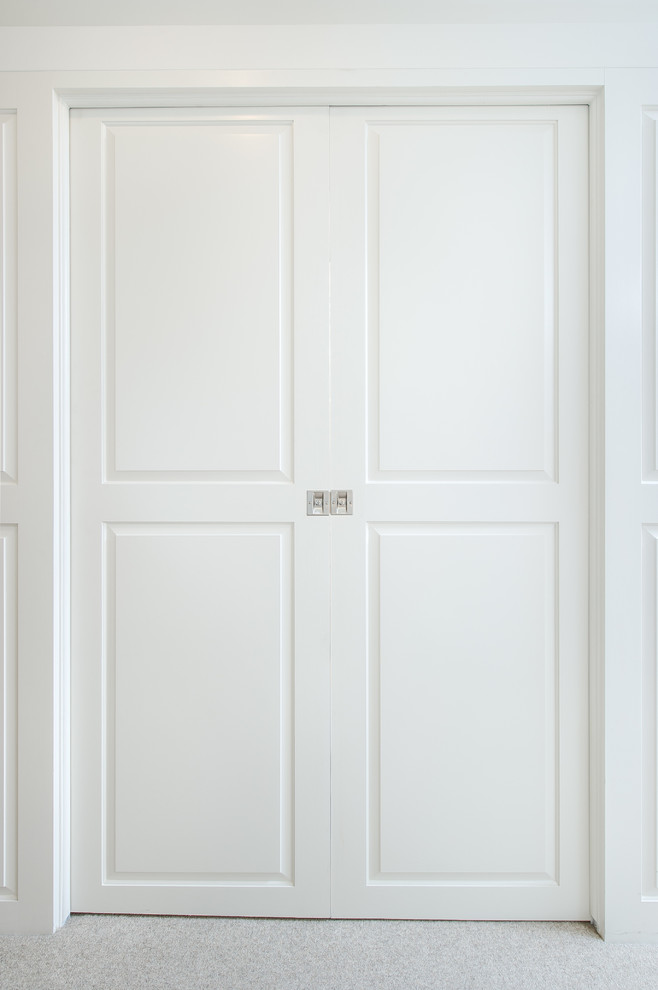 Example of a small classic women's carpeted walk-in closet design in Los Angeles with raised-panel cabinets and white cabinets