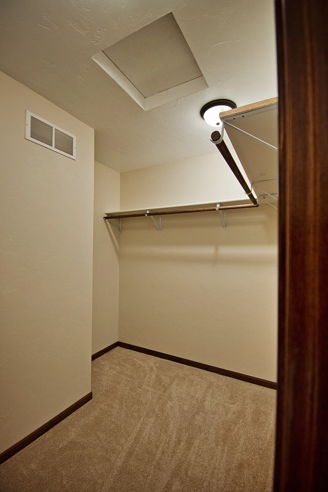 На фото: гардеробная комната среднего размера, унисекс в стиле неоклассика (современная классика) с ковровым покрытием и бежевым полом с