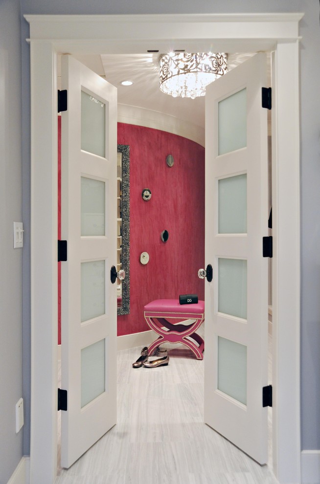 Immagine di una cabina armadio minimal di medie dimensioni con ante lisce, ante bianche e pavimento in marmo