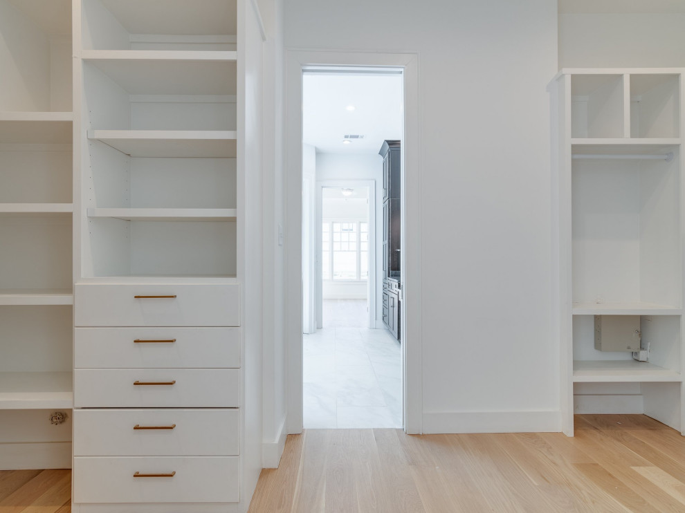 Example of an arts and crafts light wood floor built-in closet design in Other