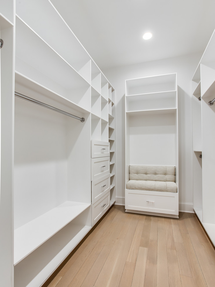 Inspiration för stora klassiska walk-in-closets för könsneutrala, med luckor med infälld panel, vita skåp och ljust trägolv