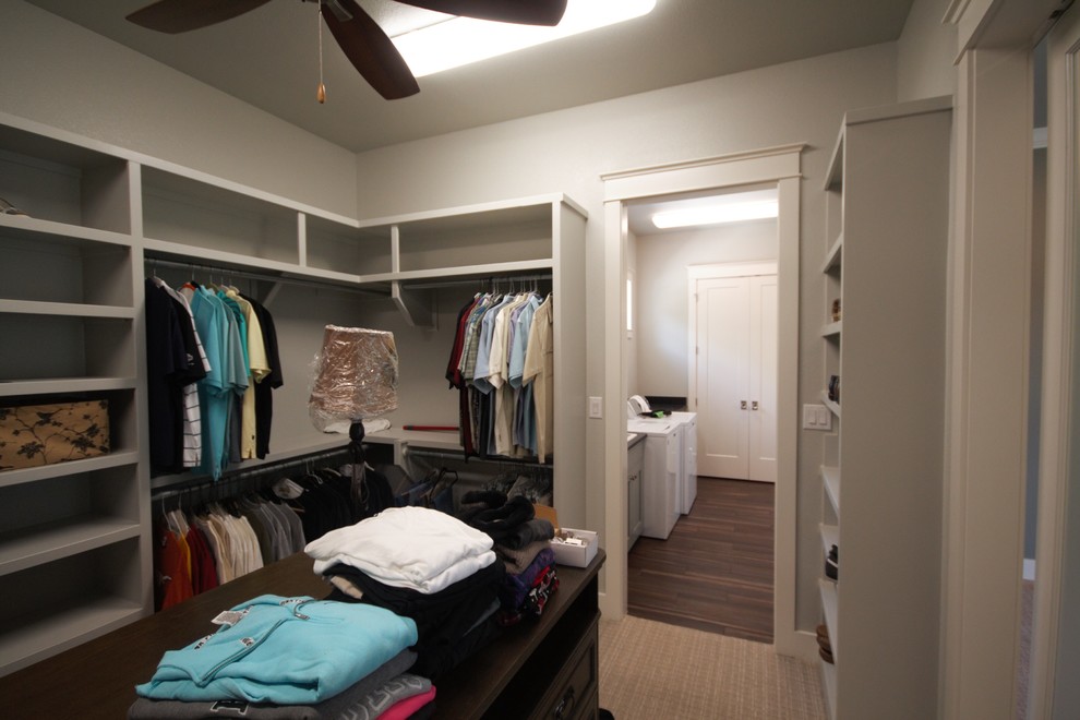 Inspiration for a large timeless gender-neutral carpeted and beige floor walk-in closet remodel in Austin with recessed-panel cabinets and dark wood cabinets