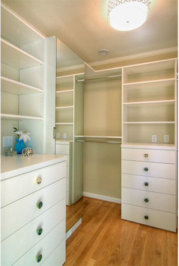 Imagen de armario vestidor unisex clásico renovado de tamaño medio con armarios con paneles lisos, puertas de armario blancas, suelo de madera clara y suelo beige