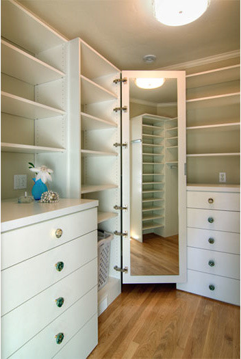 Foto de armario vestidor unisex tradicional renovado de tamaño medio con armarios con paneles lisos, puertas de armario blancas, suelo de madera clara y suelo marrón