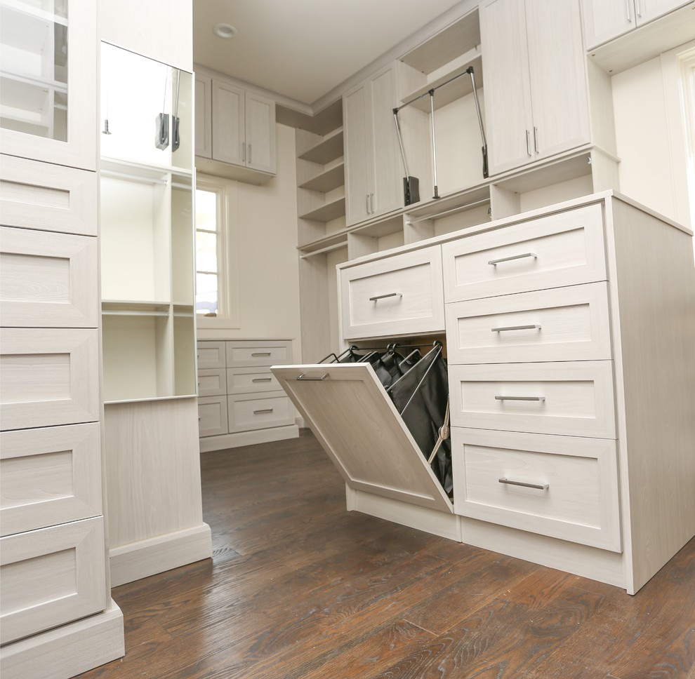 Example of a huge trendy gender-neutral brown floor and medium tone wood floor walk-in closet design in Atlanta with shaker cabinets and light wood cabinets