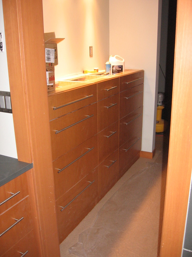Foto de vestidor unisex actual de tamaño medio con armarios con paneles lisos, puertas de armario de madera clara y moqueta