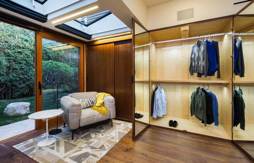 Reach-in closet - mid-sized contemporary gender-neutral medium tone wood floor and brown floor reach-in closet idea in Los Angeles with flat-panel cabinets and dark wood cabinets