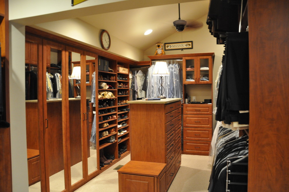 Ejemplo de armario vestidor clásico grande con armarios con paneles con relieve, puertas de armario de madera oscura y moqueta
