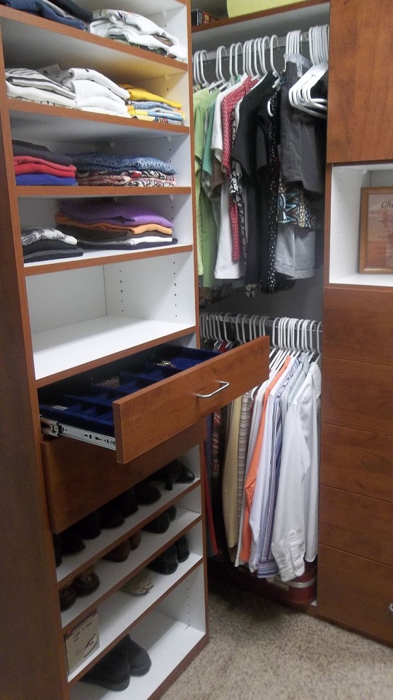 Ejemplo de armario vestidor tradicional de tamaño medio con armarios con paneles lisos, puertas de armario de madera oscura y moqueta