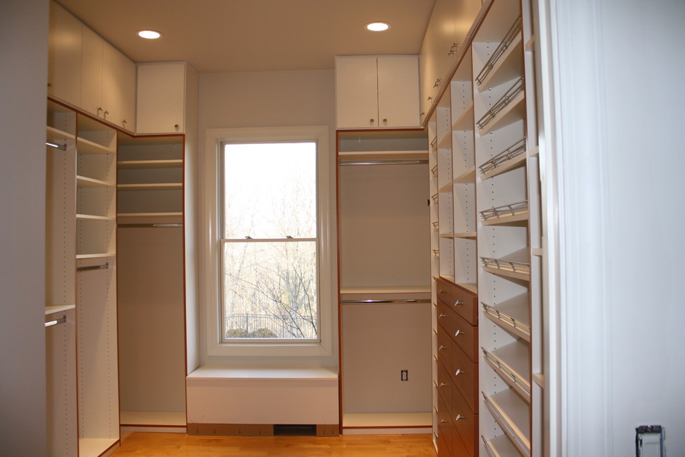 Пример оригинального дизайна: большая гардеробная комната в стиле модернизм с плоскими фасадами, белыми фасадами и ковровым покрытием